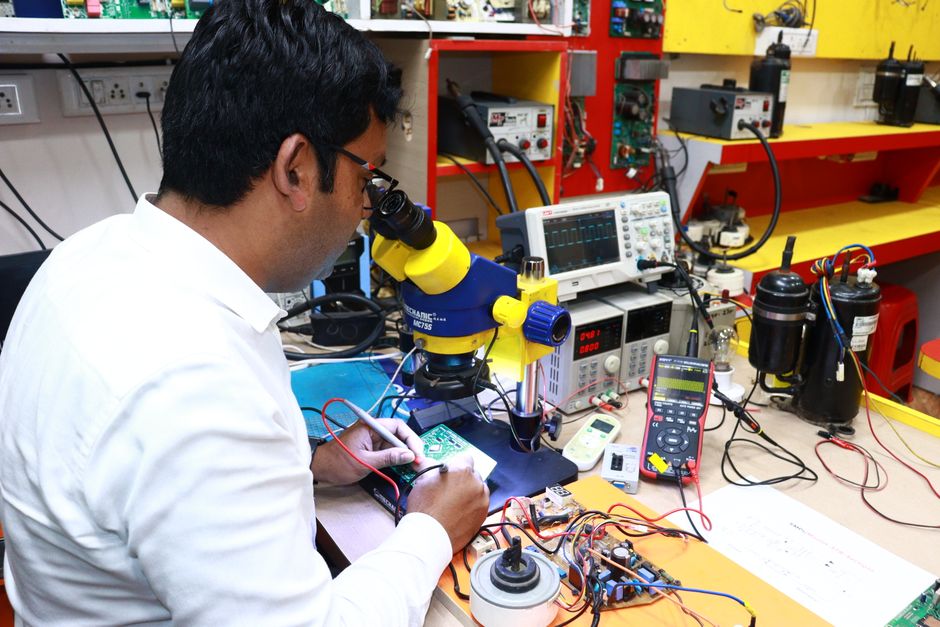 Tehničar popravlja tiskanu pločicu pod mikroskopom u elektroničkom laboratoriju